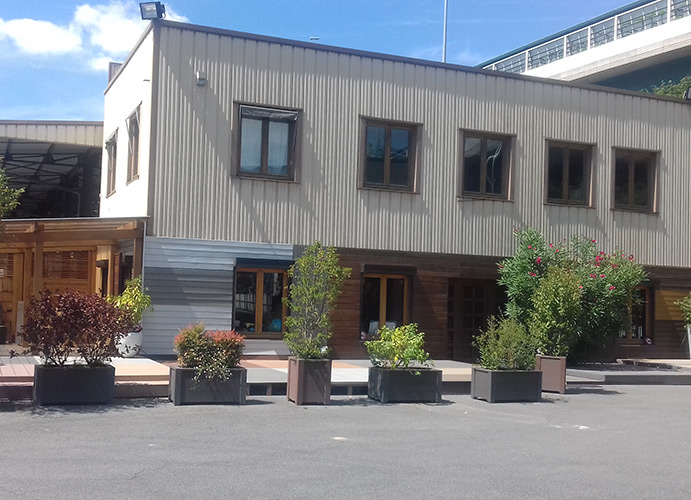 Bâtiment bois blanc avec plante devant